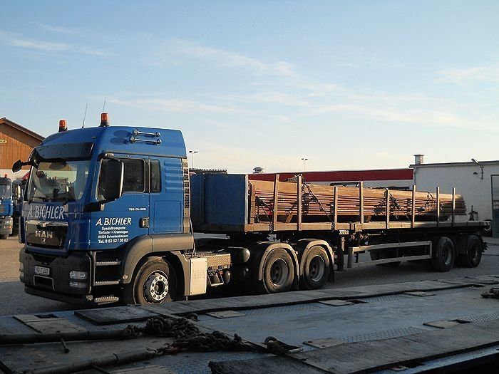 Blauer LKW transportiert Baustahl auf offener Ladefläche