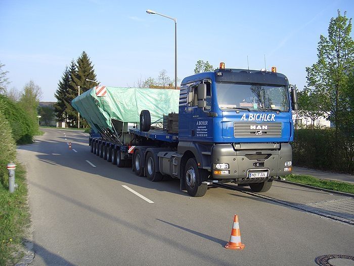 Blauer Schwertransport-LKW mit breiter Schweißkonstruktion auf der Ladefläche